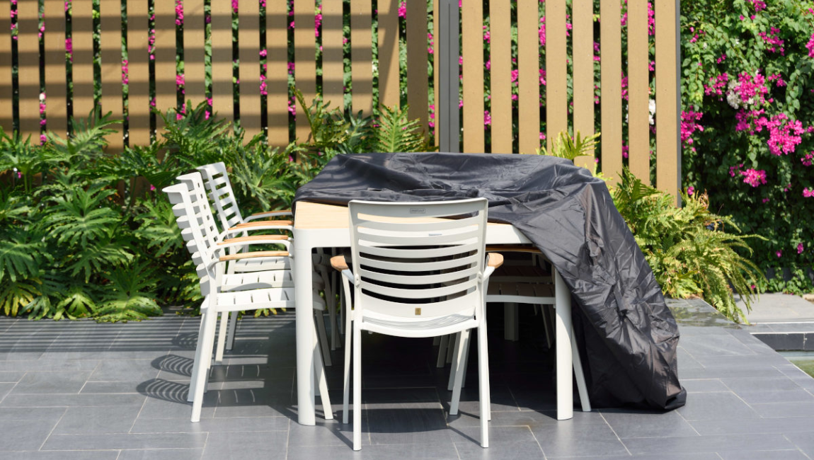 White garden set covered with furniture cover.